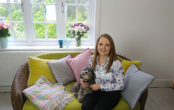 Freelance Alcohol Reduction Hypnotherapy Specialist Ailsa Frank in her Ascot home office sat on the sofa next to her adorable dog.