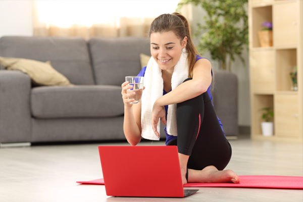 Lady with red laptop chatting to her PT via Skype after a workout sessions