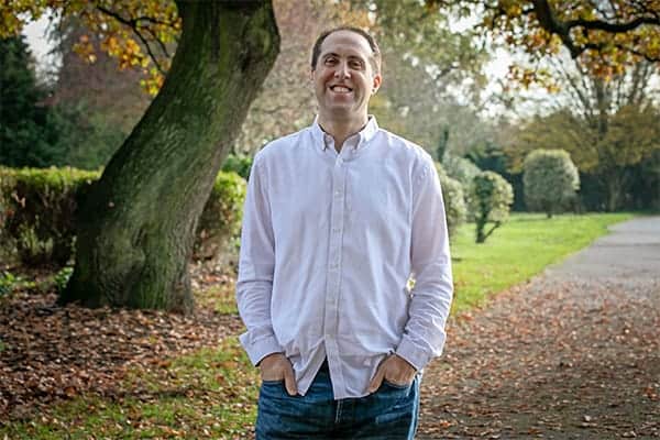 Starting a freelance consulting business during a pandemic - Communications Consultant Michael Rosen smiling, stood in the park.