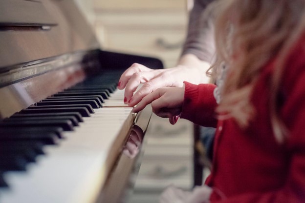 A piano tutor teaching a young student.