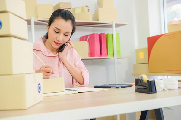 A small business owner taking orders over the phone.